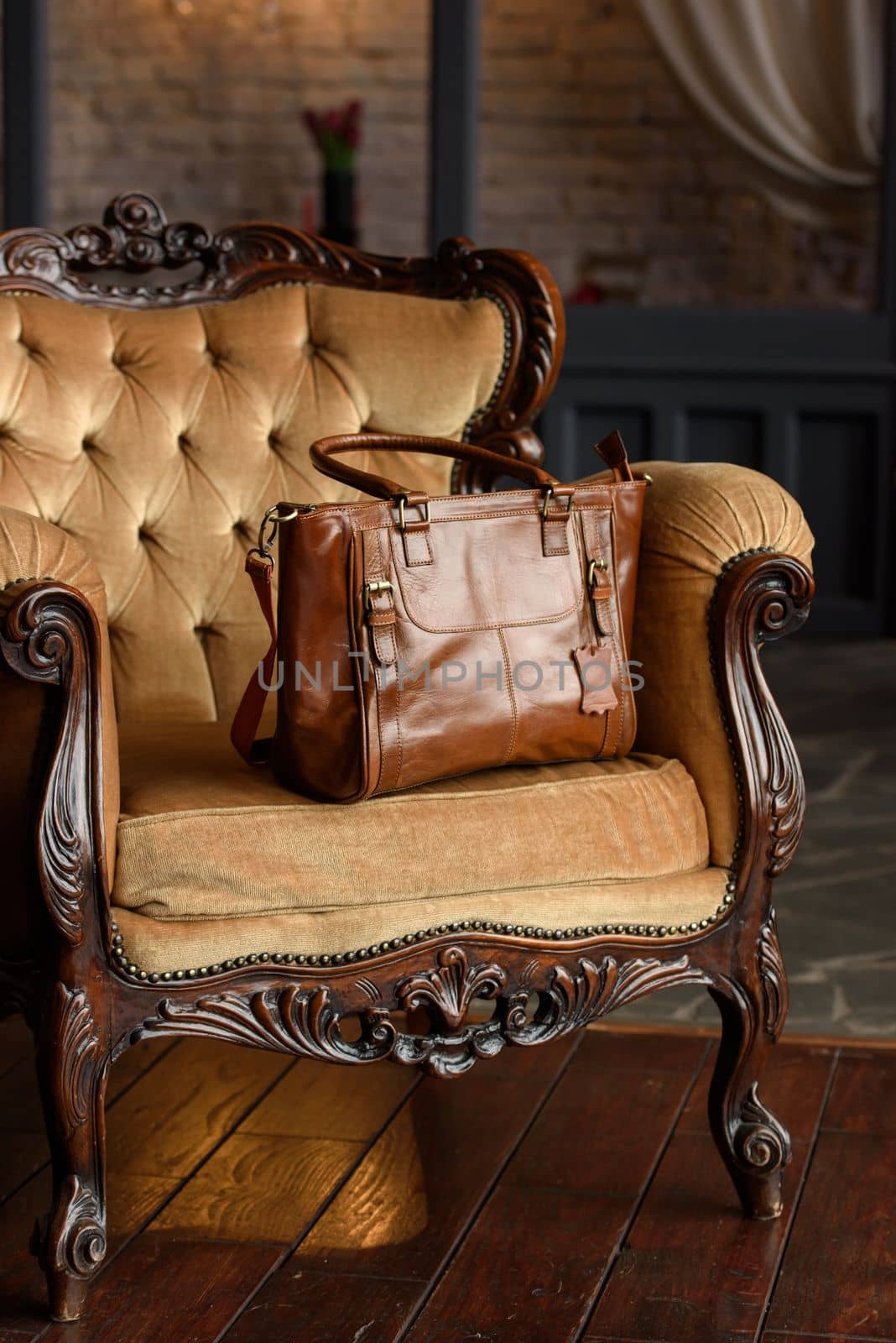 close-up photo of brown leather bag on a yellow velor vintage armchair. indoor photo