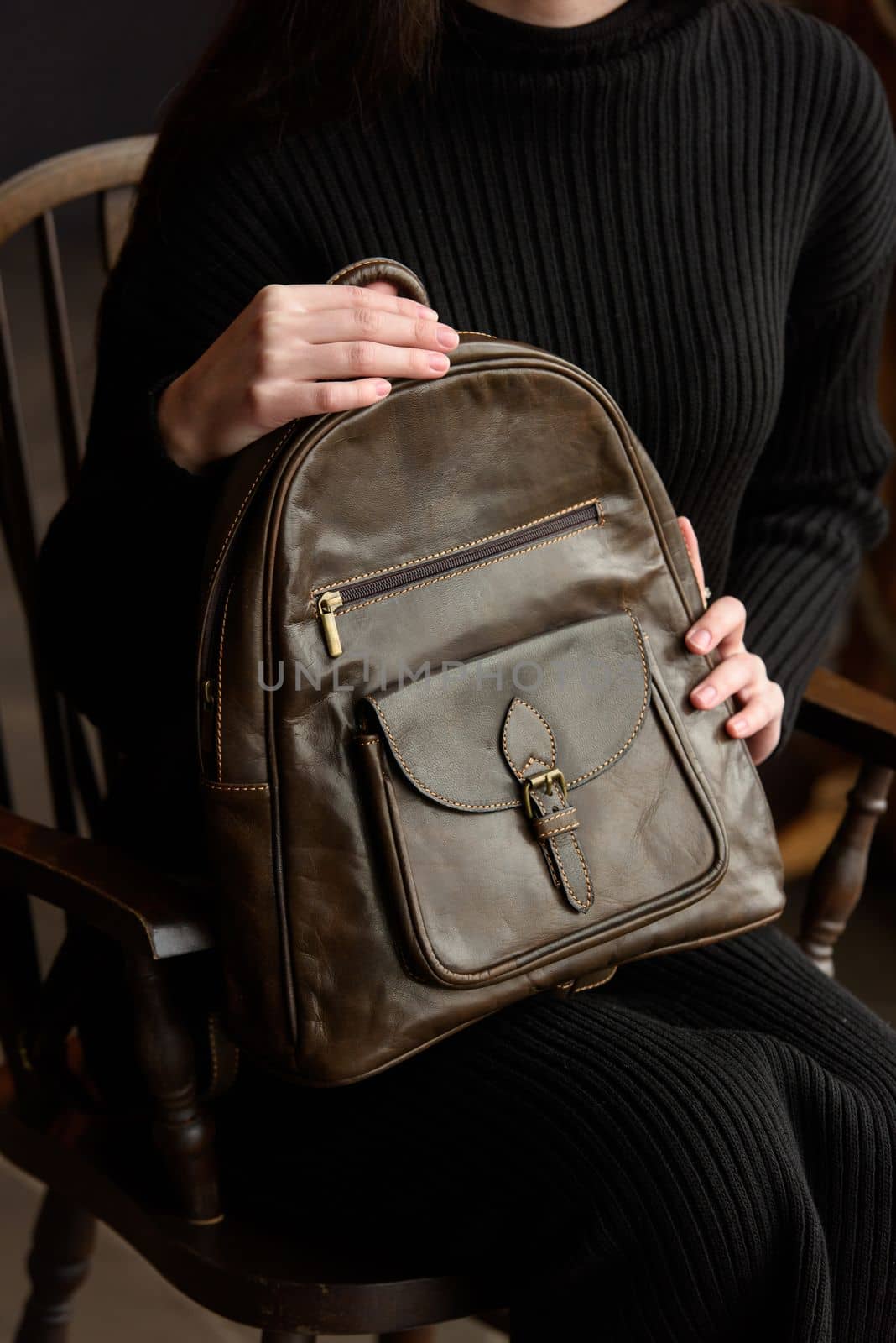 photo of a woman with a brown leather backpack with antique and retro look. indoors photo by Ashtray25