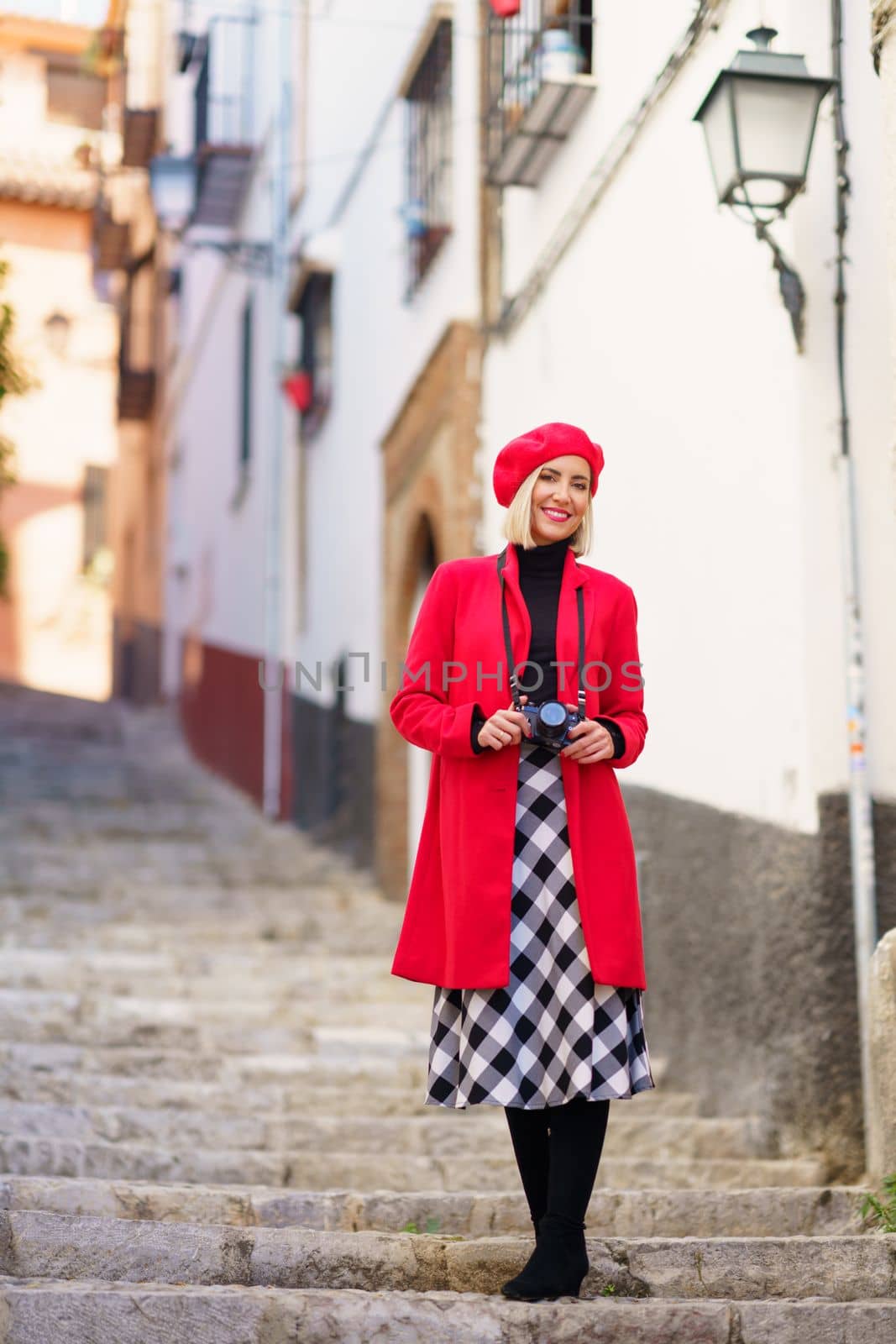 Stylish travelling lady standing on stairs in town and smiling by javiindy