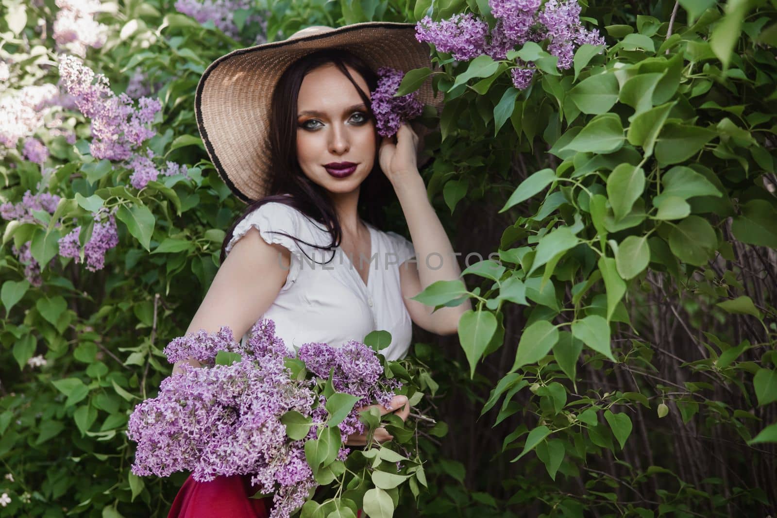 A fashionable girl with dark hair, a spring portrait in lilac tones in summer. Bright professional makeup