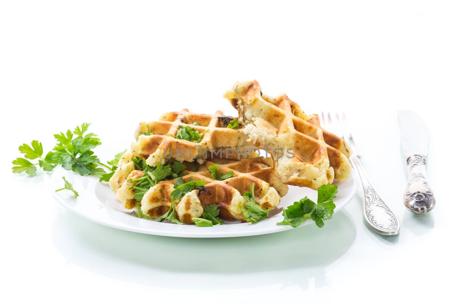 fried Belgian vegetable waffles with spices and herbs, in a plate isolated on white background.