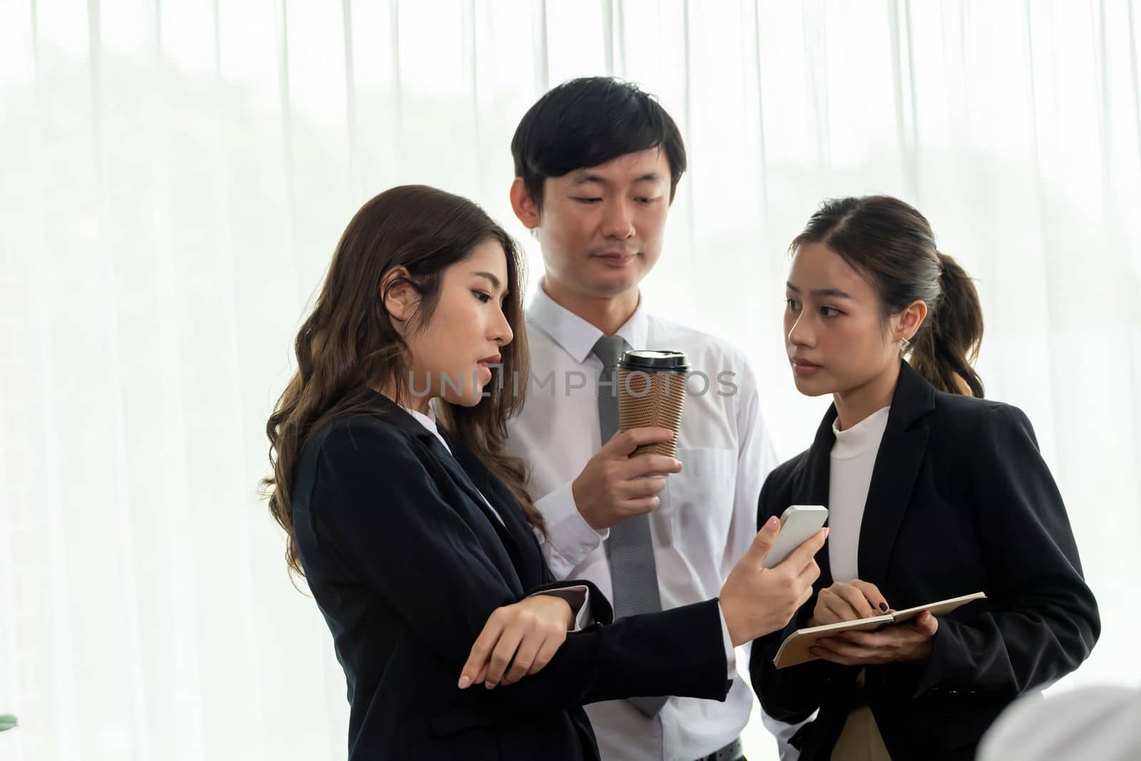 Mentor, manager with coffee advice younger colleagues in workplace. Businesspeople discussing or planning financial project strategy, talking together for harmony and strong teamwork in office concept