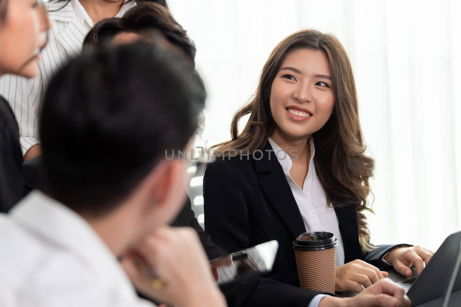 Focus portrait of female manger, businesswoman in the harmony meeting room with blurred of colleagues working together, analyzing financial paper report and dashboard data in background.