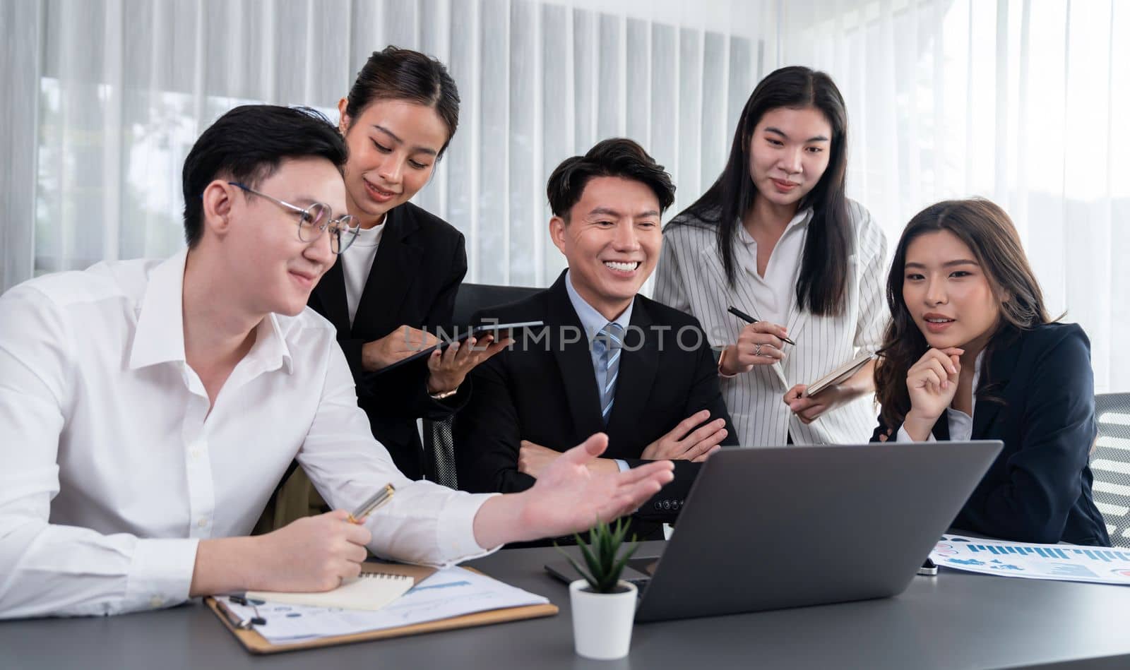 Harmony in office concept as business people analyzing dashboard paper together in workplace. Young colleagues give ideas at manager desk for discussion or strategy planning about project.