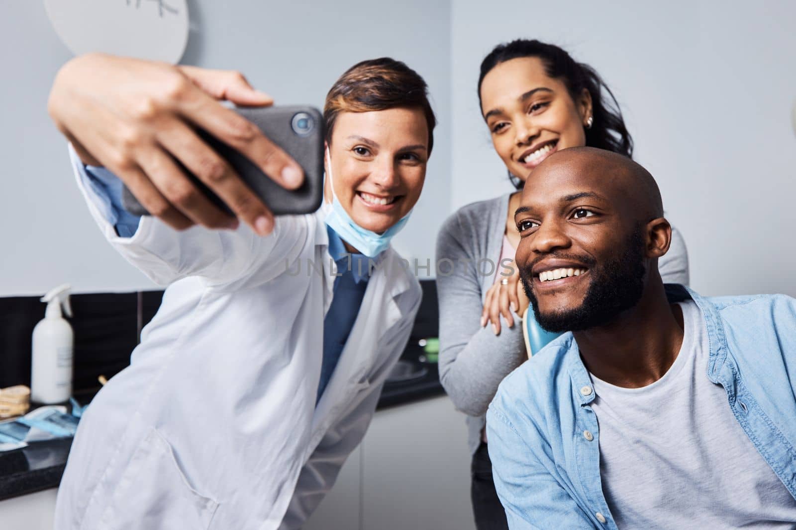 Make your smile the star of the show. a young woman taking selfies with her patient after his dental procedure. by YuriArcurs