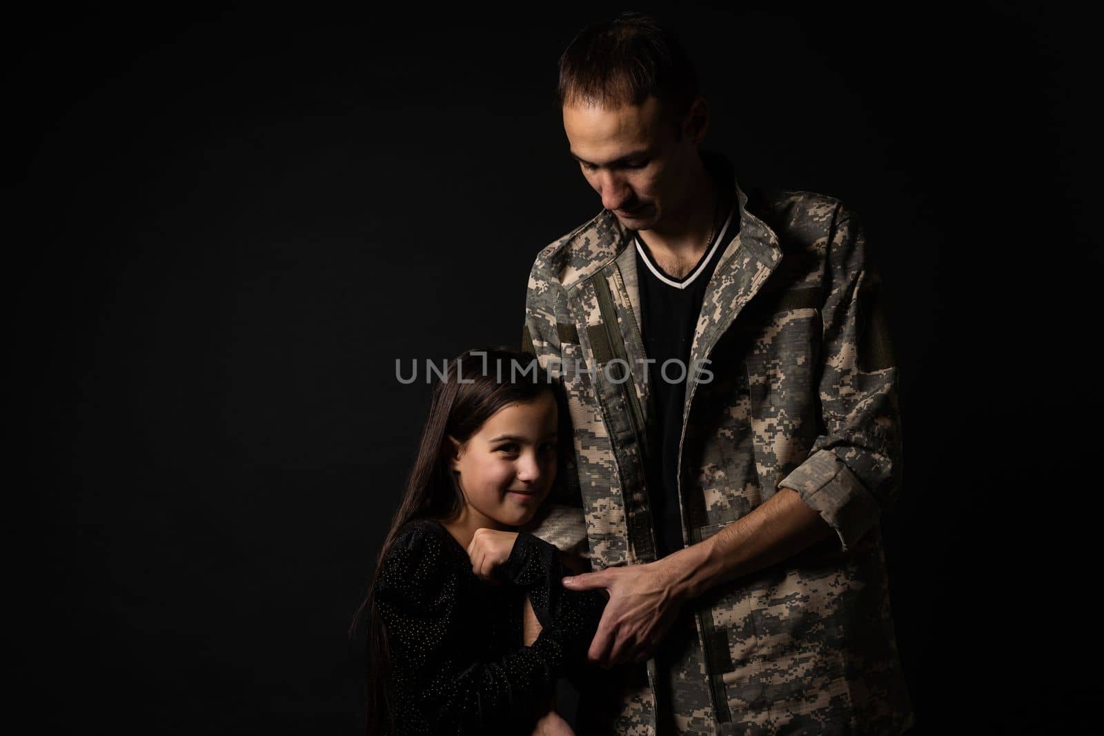 military man and daughter on a black background