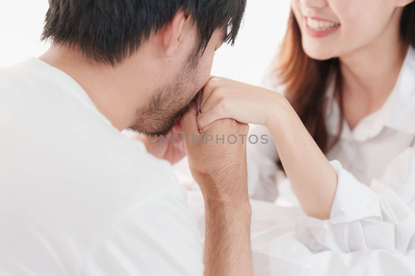 Beautiful asian couple in love and smiling sitting on bed. Romantic moment, relationships, family concept