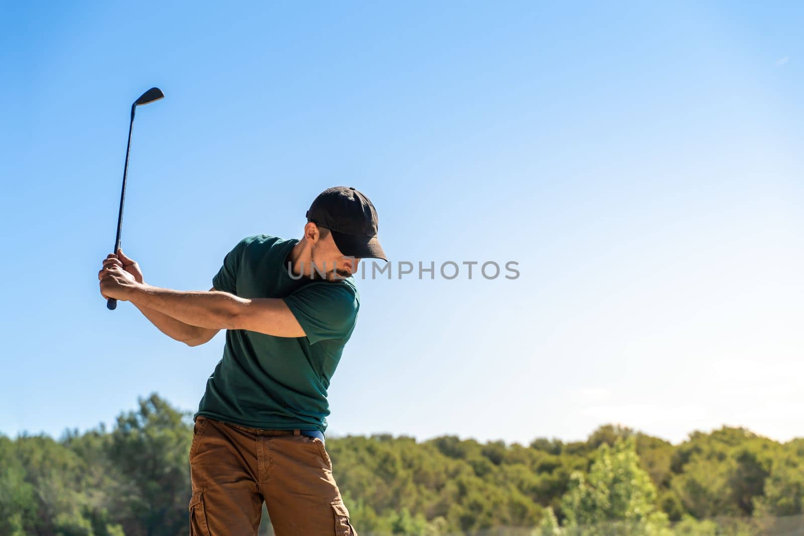 Young man playing golf in summer. Lifestyle game. Healthy and sporty outdoors. Concentration skills concept. High quality photo