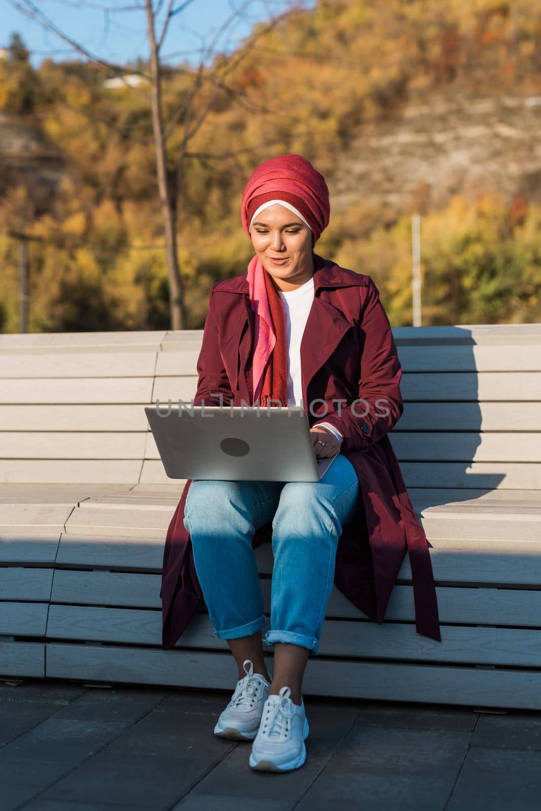 Female muslim arabian student in hijab holding laptop outdoors - freelancer, blogger and diversity