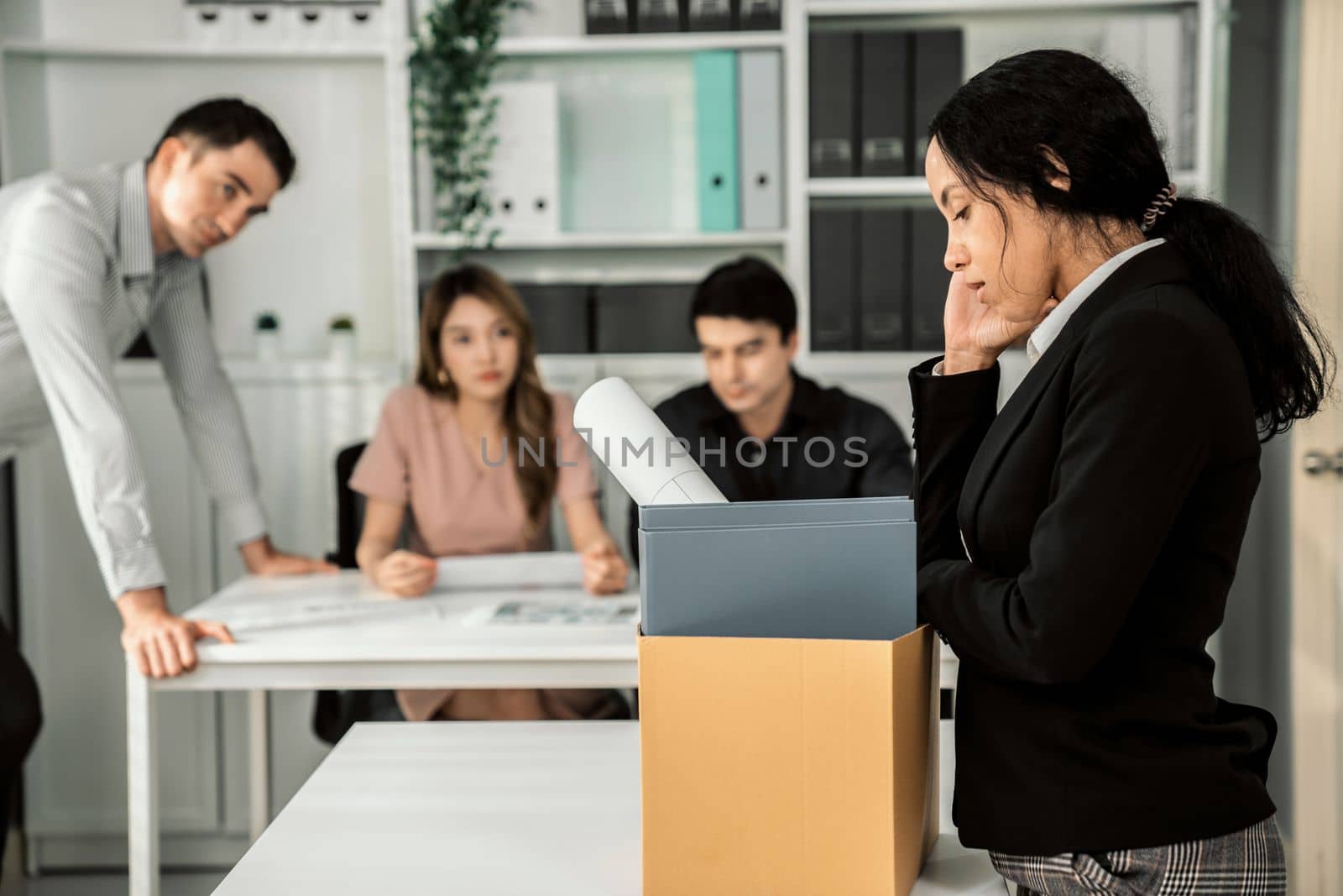 Depressed and disappointed employee packing her belongings after being fired for not being competent. Gossiped by her colleagues behind his back. Layoff due to economic depression.