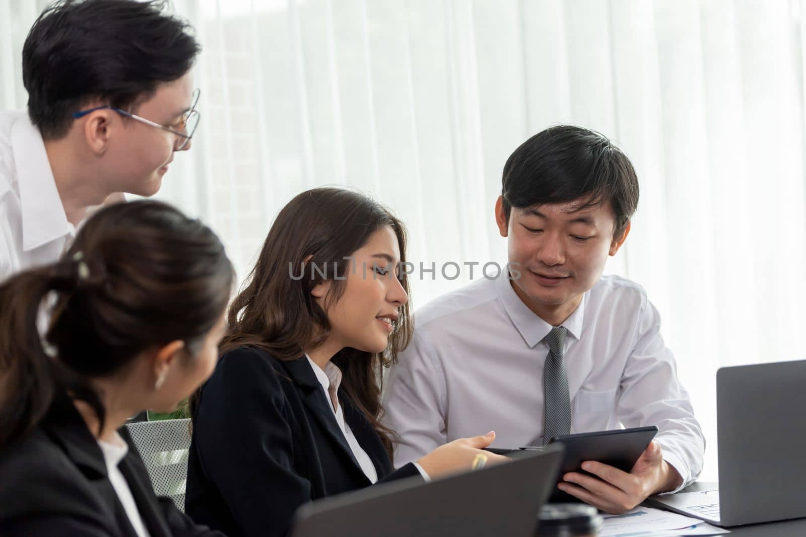 Harmony in office concept as business people analyzing dashboard paper together in workplace. Young colleagues give ideas at manager desk for discussion or strategy planning about project.