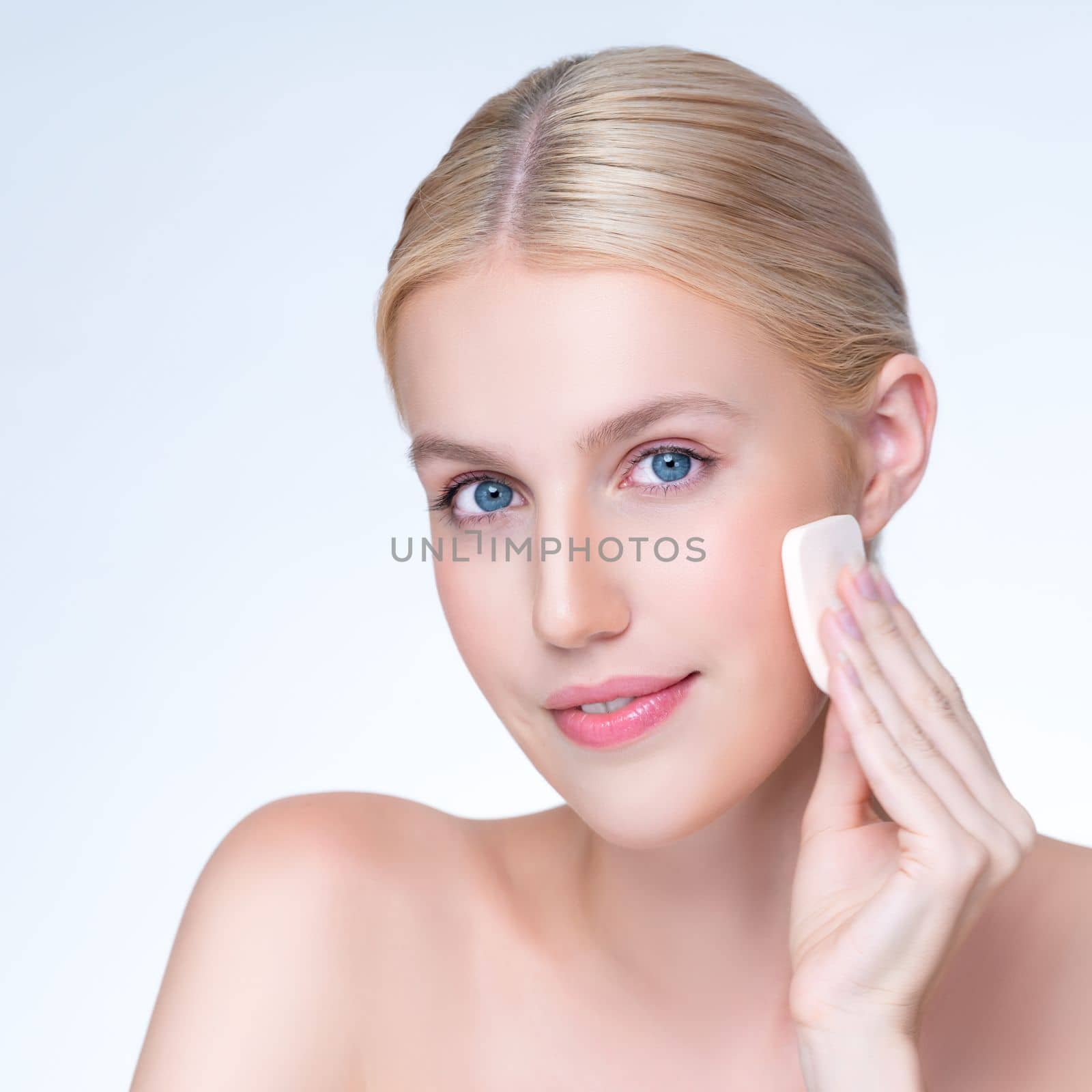 Closeup personable natural makeup woman using powder puff for facial makeup. by biancoblue