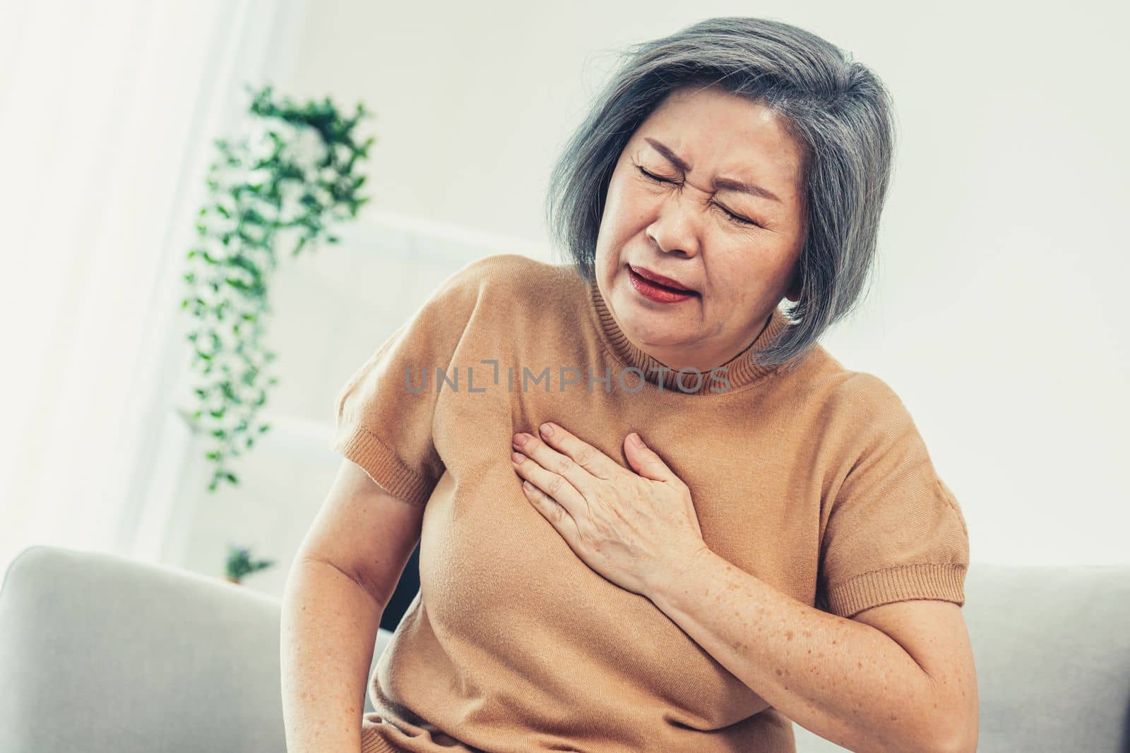 An agonizing elderly woman is experiencing chest pain. by biancoblue