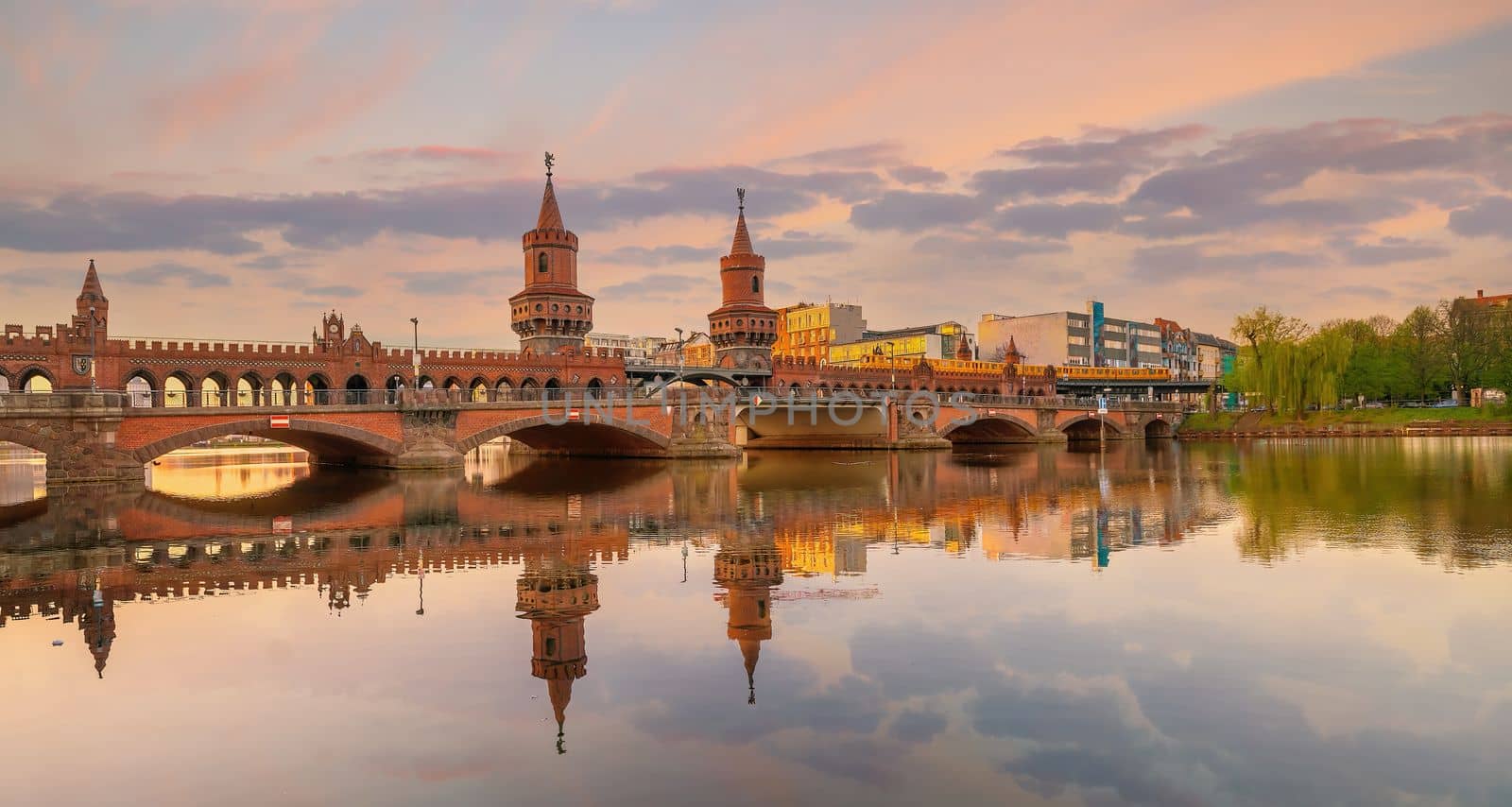 Berlin city skyline at Oberbaum Bridge and Spree River in Germany at sunset