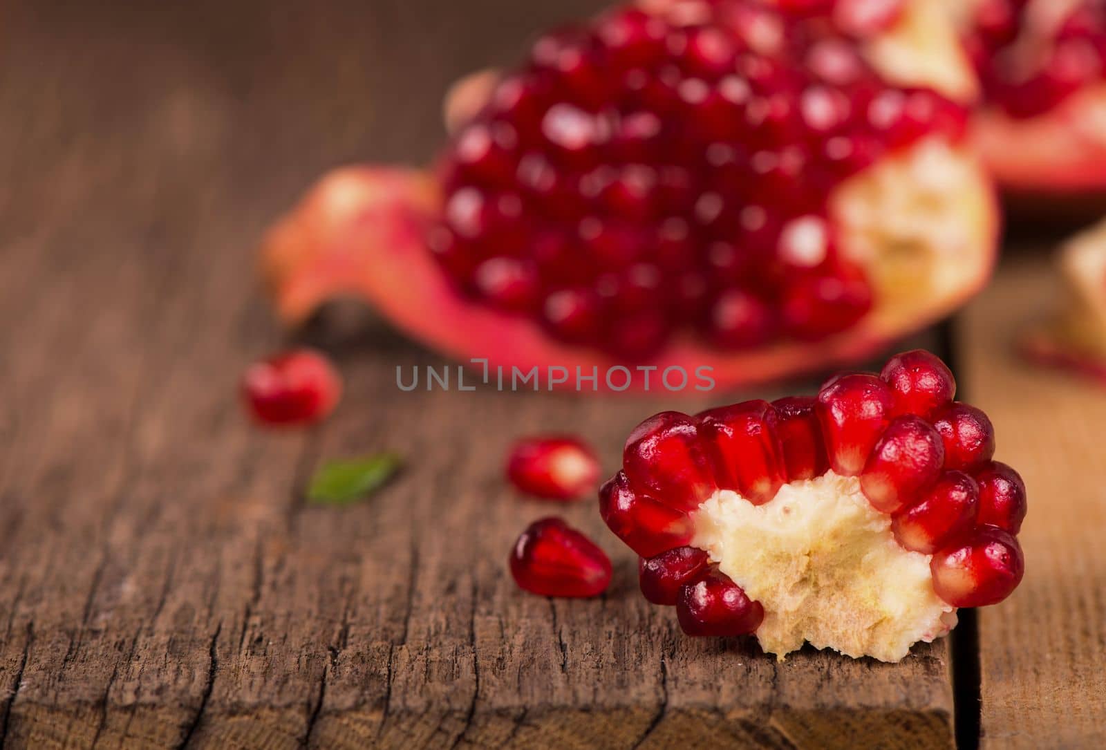 pomegranates on a wooden background by aprilphoto