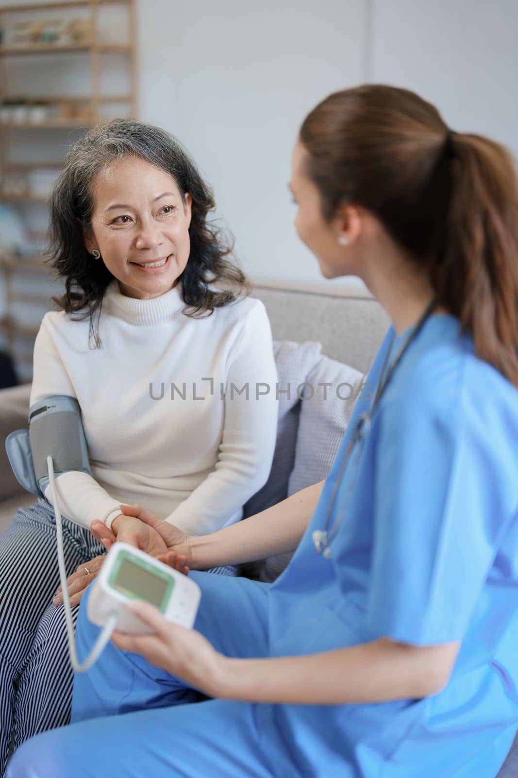 Portrait of female doctor measuring patient's blood pressure before treatment