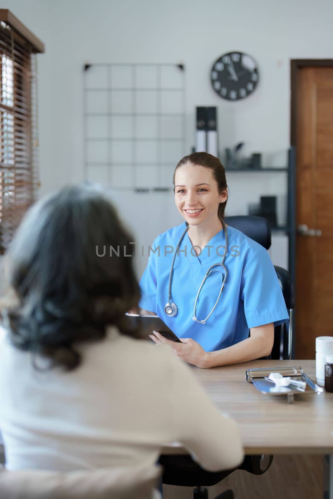 Portrait of a female doctor holding tablet computer to discuss and analyze the patient's condition before treating