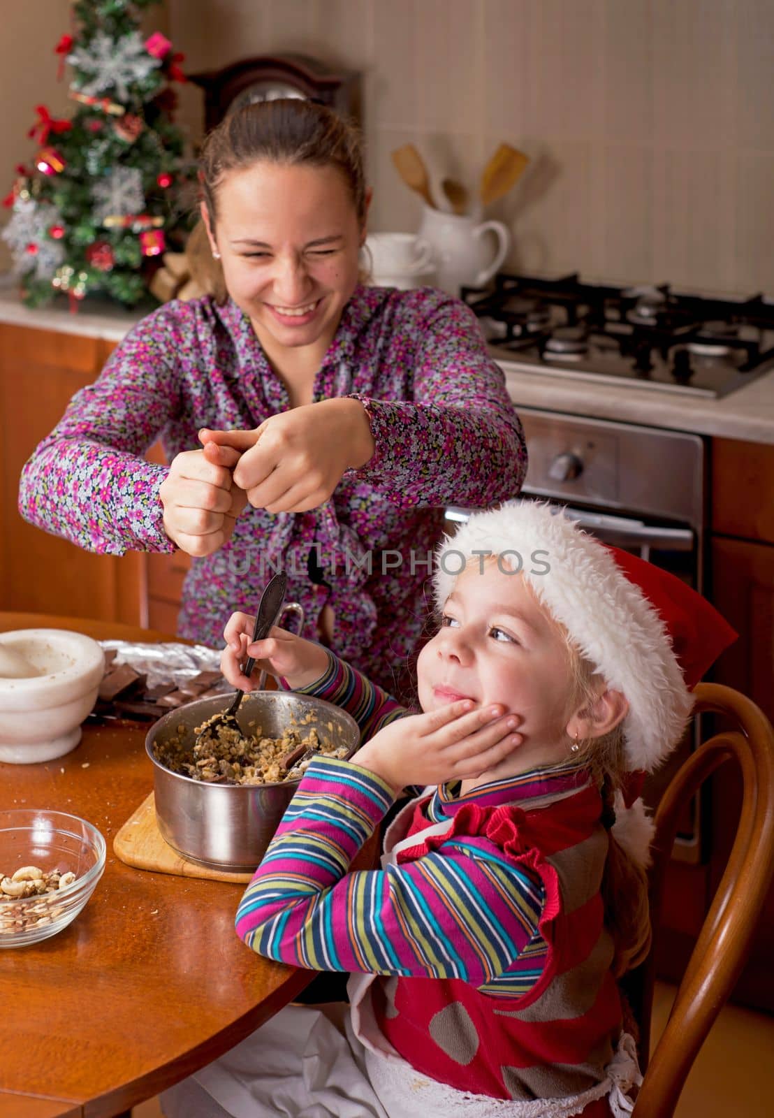 Christmas atmosphere. Children drink tea. Depps have prepared Christmas cookies and have fun in the kitchen at their home by aprilphoto