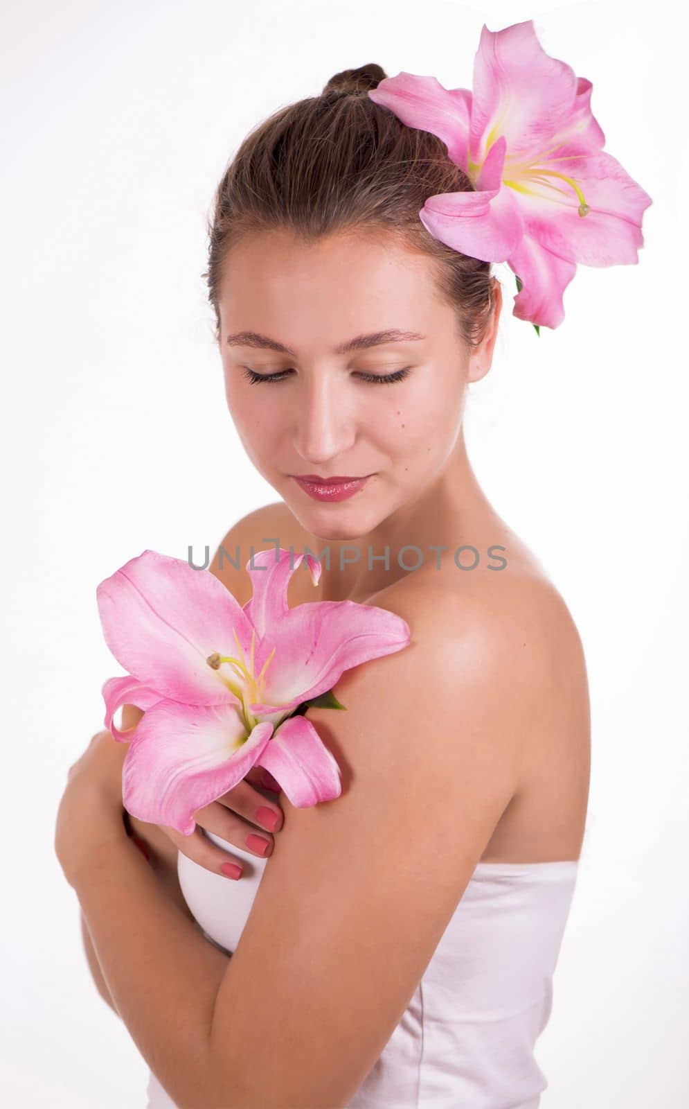 Beauty face of the young beautiful woman with flower. Female touching skin. by aprilphoto