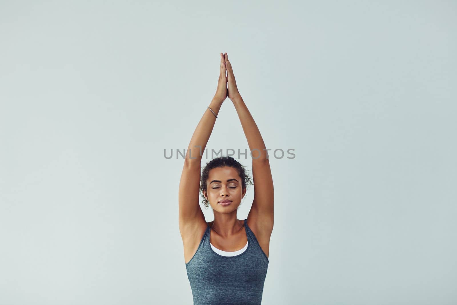 Yoga is the journey and the destination. Studio shot of an attractive young woman practicing yoga against a grey background
