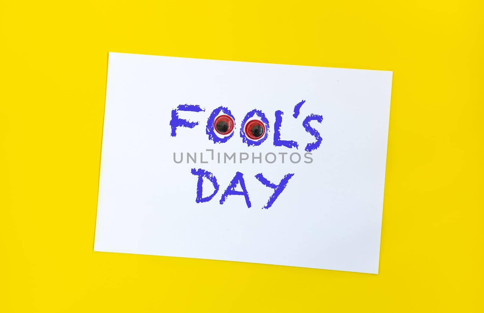 Text word Fool's day on sheet of paper with funny eyes and. 1 april message handwritting on sheet of paper. Bright yellow background. International humor day by Ri6ka