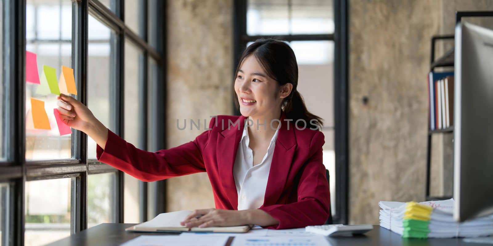 Young businesswoman creative team using post it notes in glass wall to writing strategy business plan to development grow to success. by wichayada