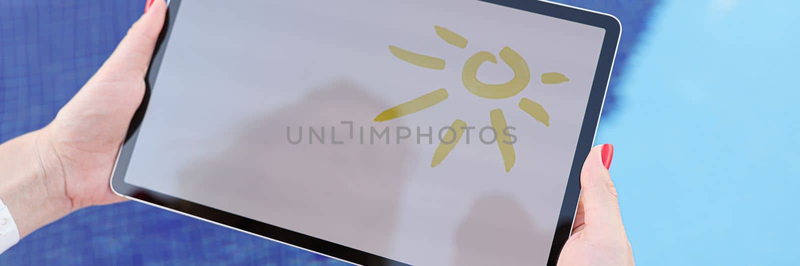 Female hands hold tablet with drawn sun and white screen above pool by kuprevich