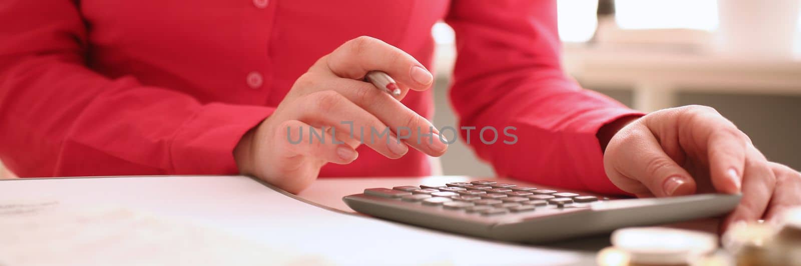 Woman secretary counts on calculator in office closeup by kuprevich