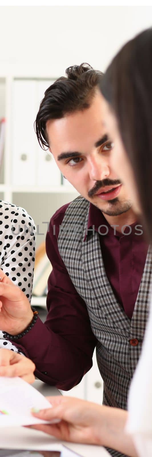 Business group of intelligent business colleagues discussing information and graphs on paper at table by kuprevich