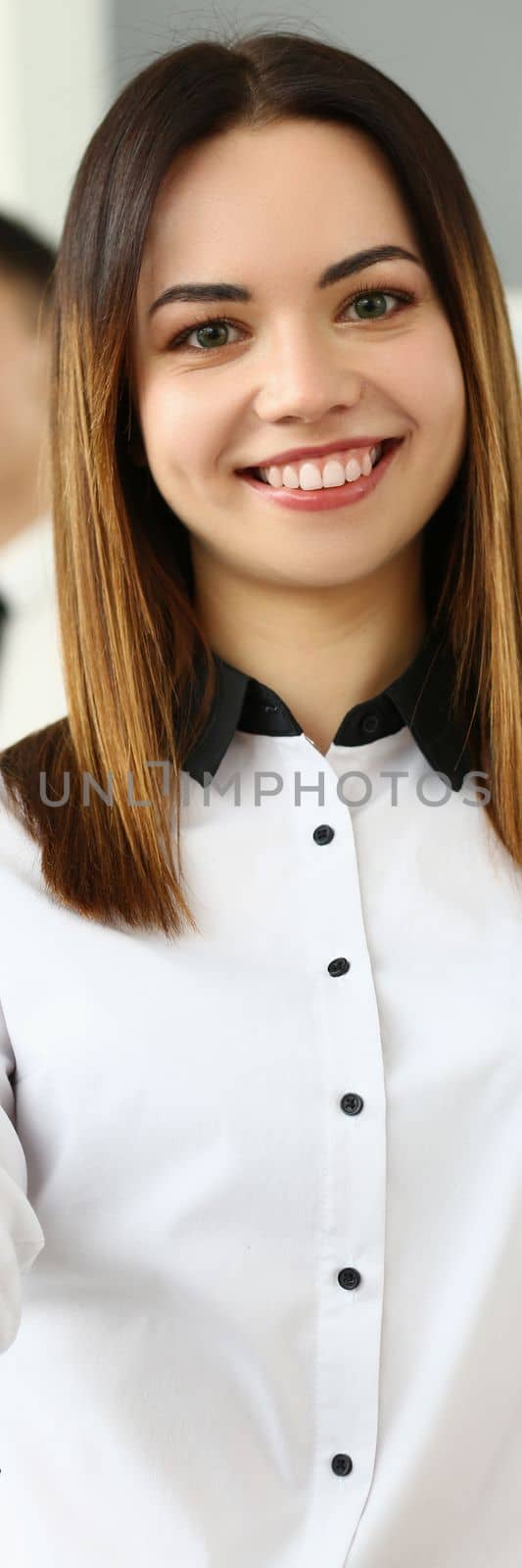 Smiling young business woman politely greets company office. Business consultant and team