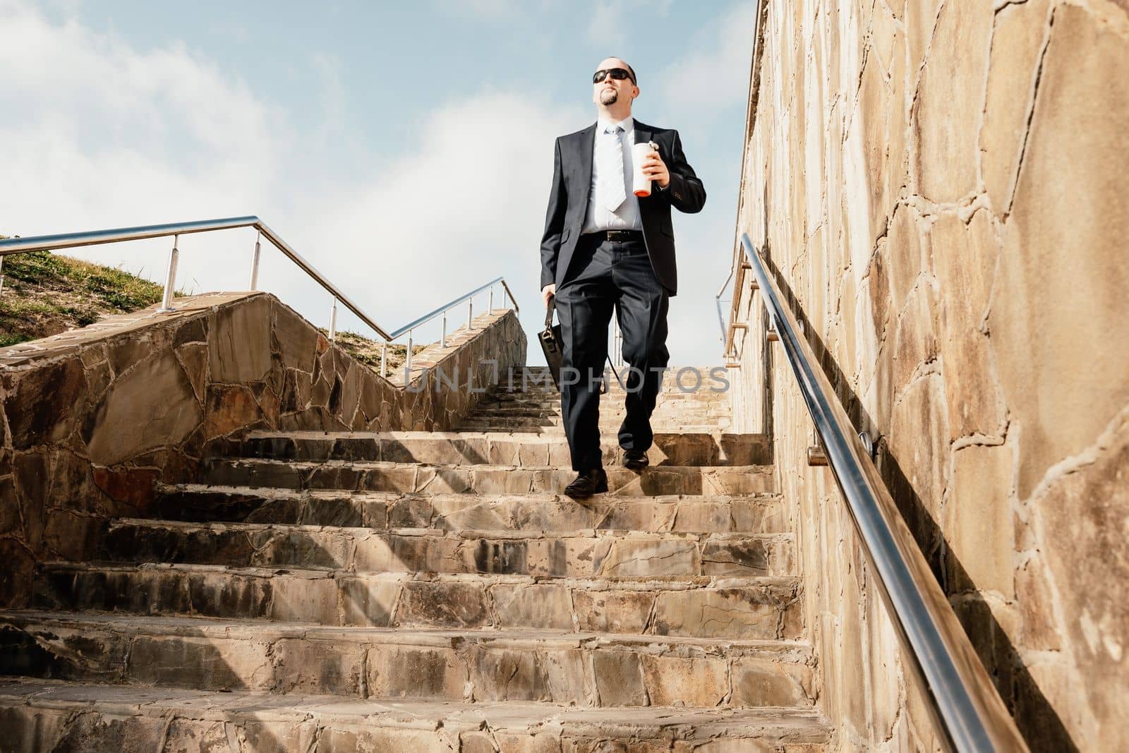 Business executive with briefcase going down the stairs.