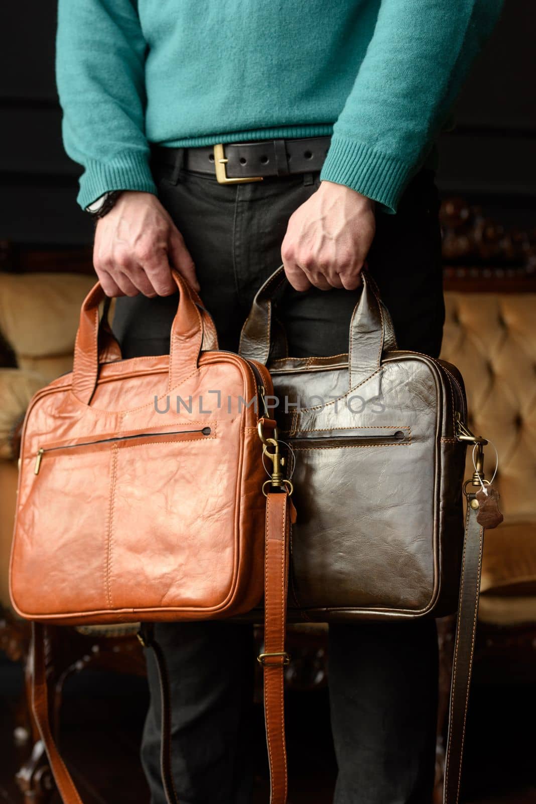 close-up photo of orange and brown leather bags corporate in mans hands. by Ashtray25