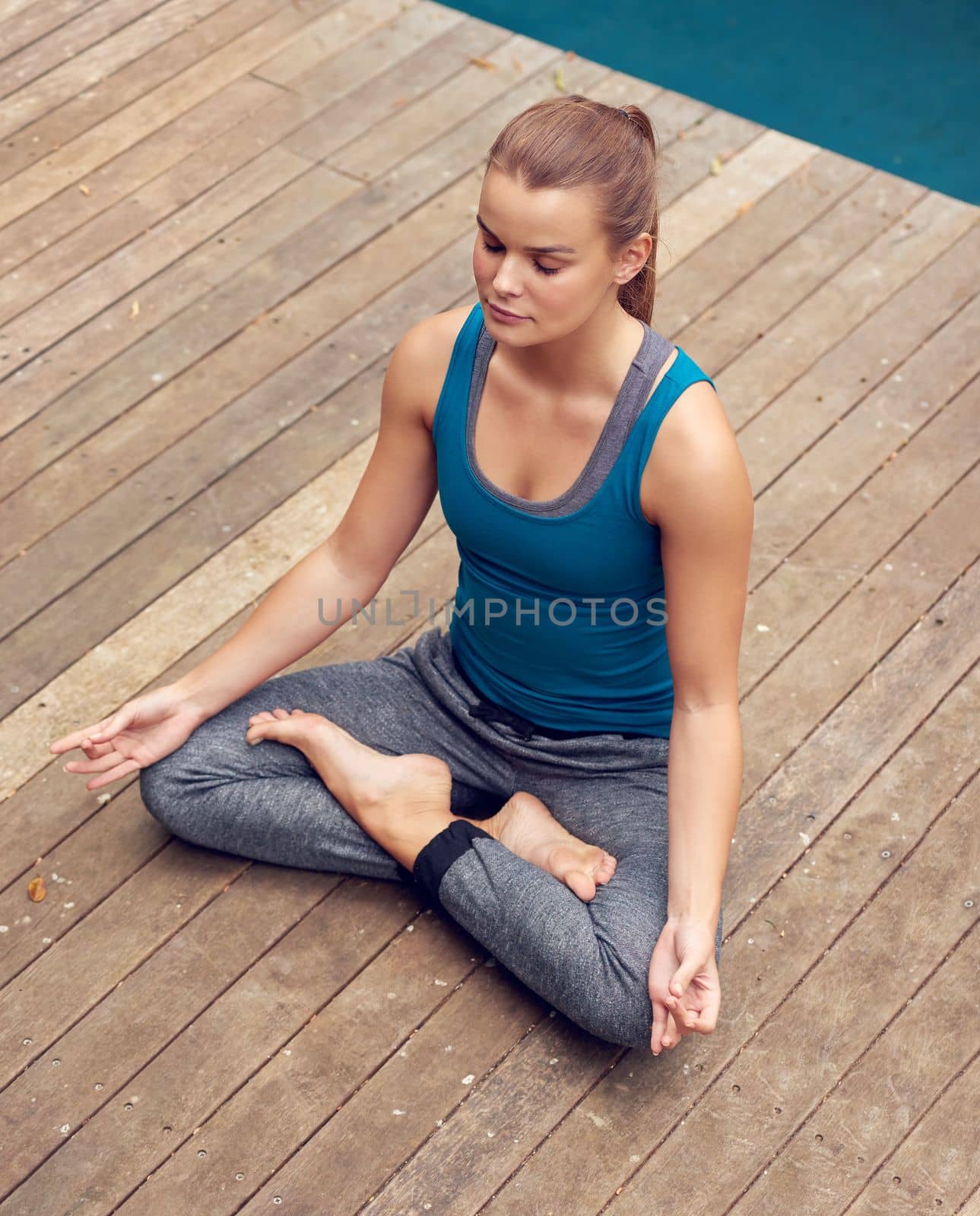 When the mind is quiet the soul will speak. a young woman practicing yoga outdoors. by YuriArcurs