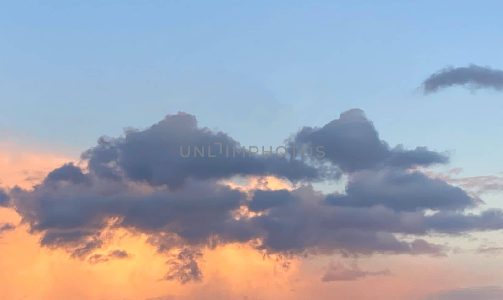 Anxious sunset. Gray and orange clouds in blue sky. by Margo