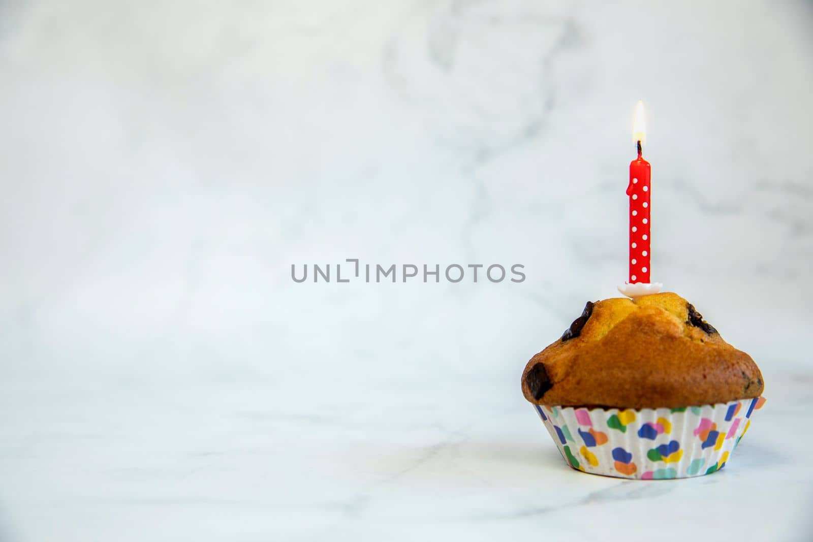 Birthday cupcake with and one red birthday cake candle on a white background with copyspace to side, Happy Birthday, party concept by Annebel146