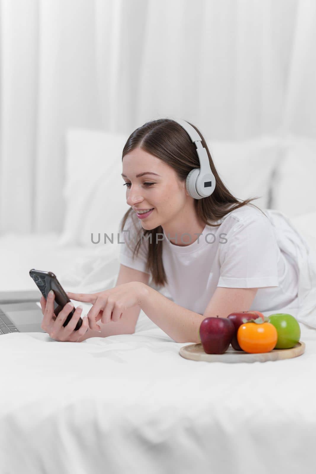 Image of beautiful young woman good healthy with headphone resting in bed at bedroom. Lifestyle at home concept.