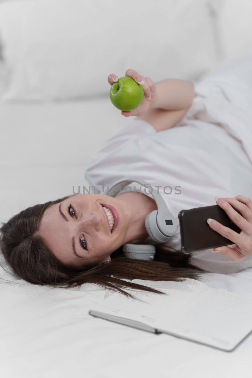 Portrait of Good Healthy woman eating green apple and resting in bed at bedroom. Lifestyle at home concept