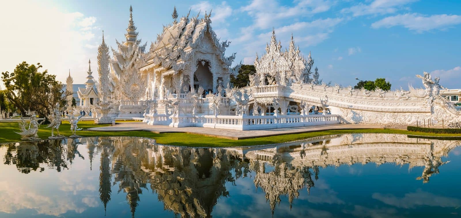 White temple Chiang Rai Thailand, Wat Rong Khun, aka The White Temple, in Chiang Rai, Thailand with a blue sky and reflection in the lake