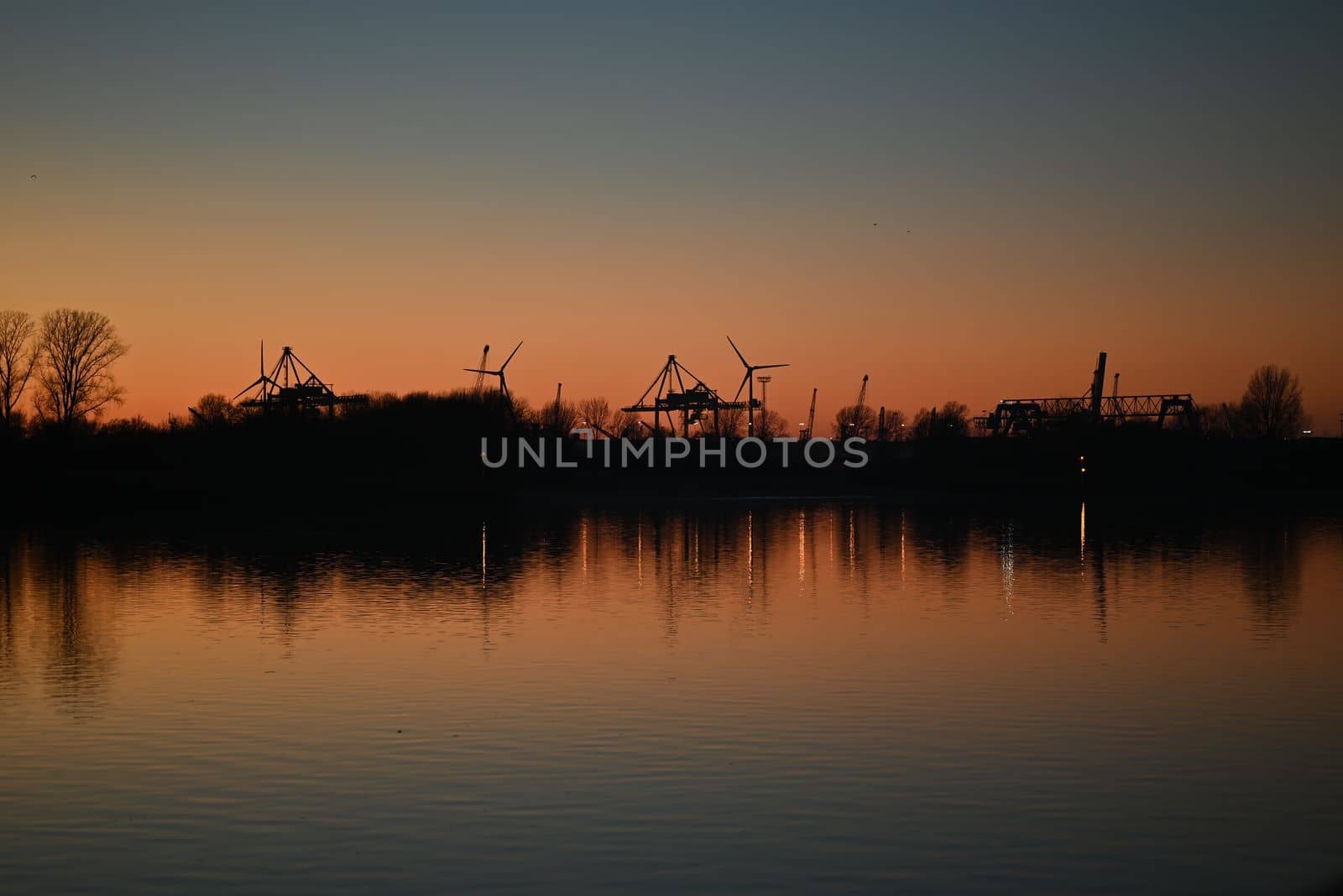 Evening mood besides a river against a containerport and sunset by Luise123