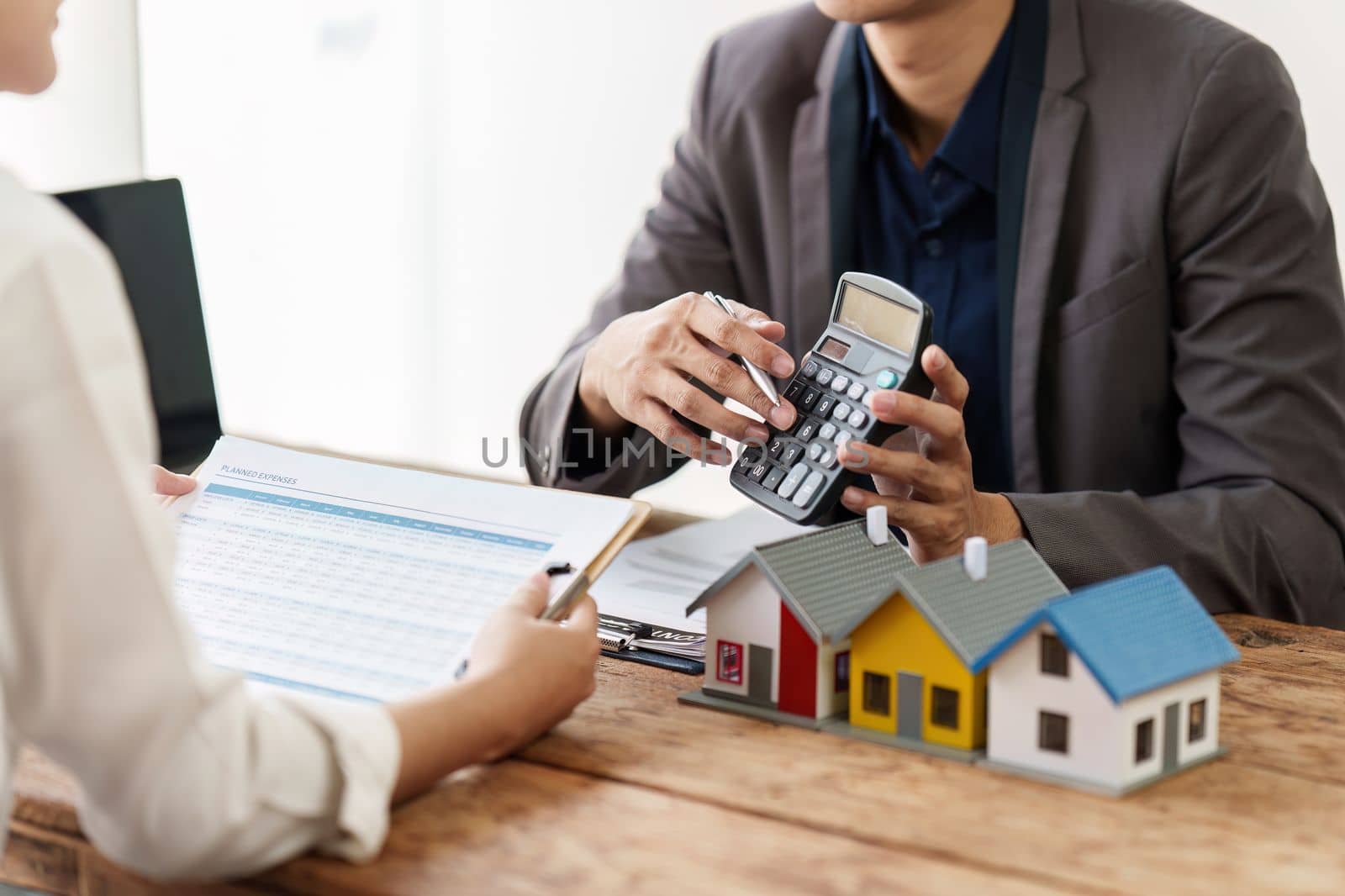 Close up Business man or Real Estate agent explain signing agreement for buying house. Bank manager and real estate concept.