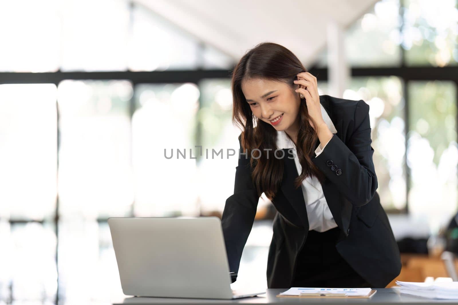Young successful woman entrepreneur or an office worker work with desk in a modern office,have happy to work by nateemee