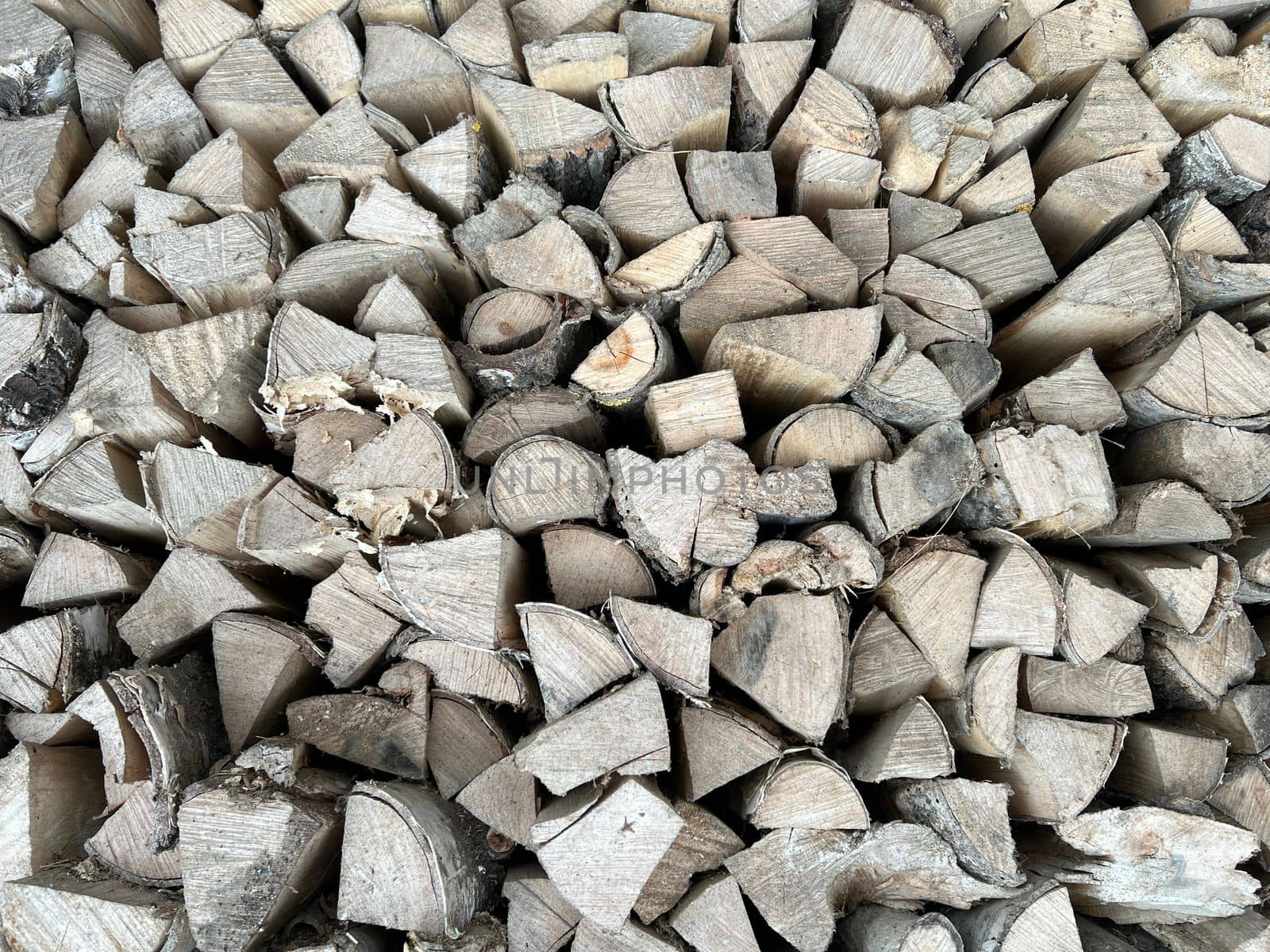 Natural wooden background - closeup of chopped firewood. Firewood stacked and prepared for winter. Wooden natural sawn logs as background