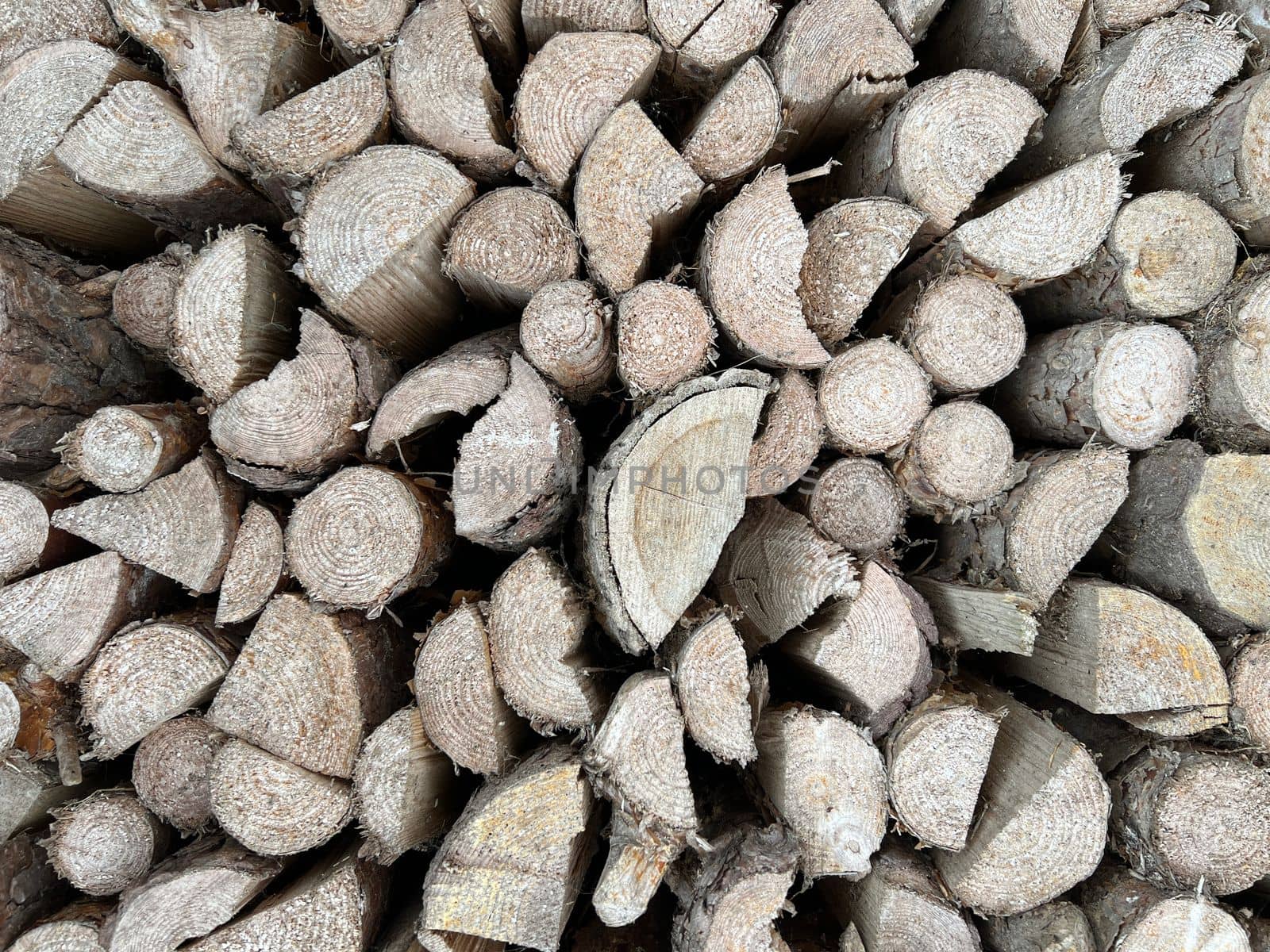 Natural wooden background - closeup of chopped firewood. Firewood stacked and prepared for winter. Wooden natural sawn logs as background