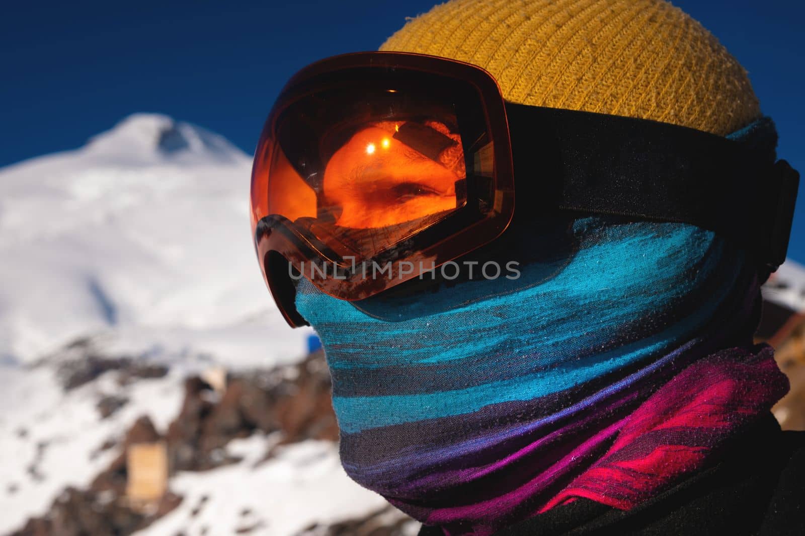 Portrait of a skier at a ski resort against the backdrop of mountains and blue sky. Winter sports.