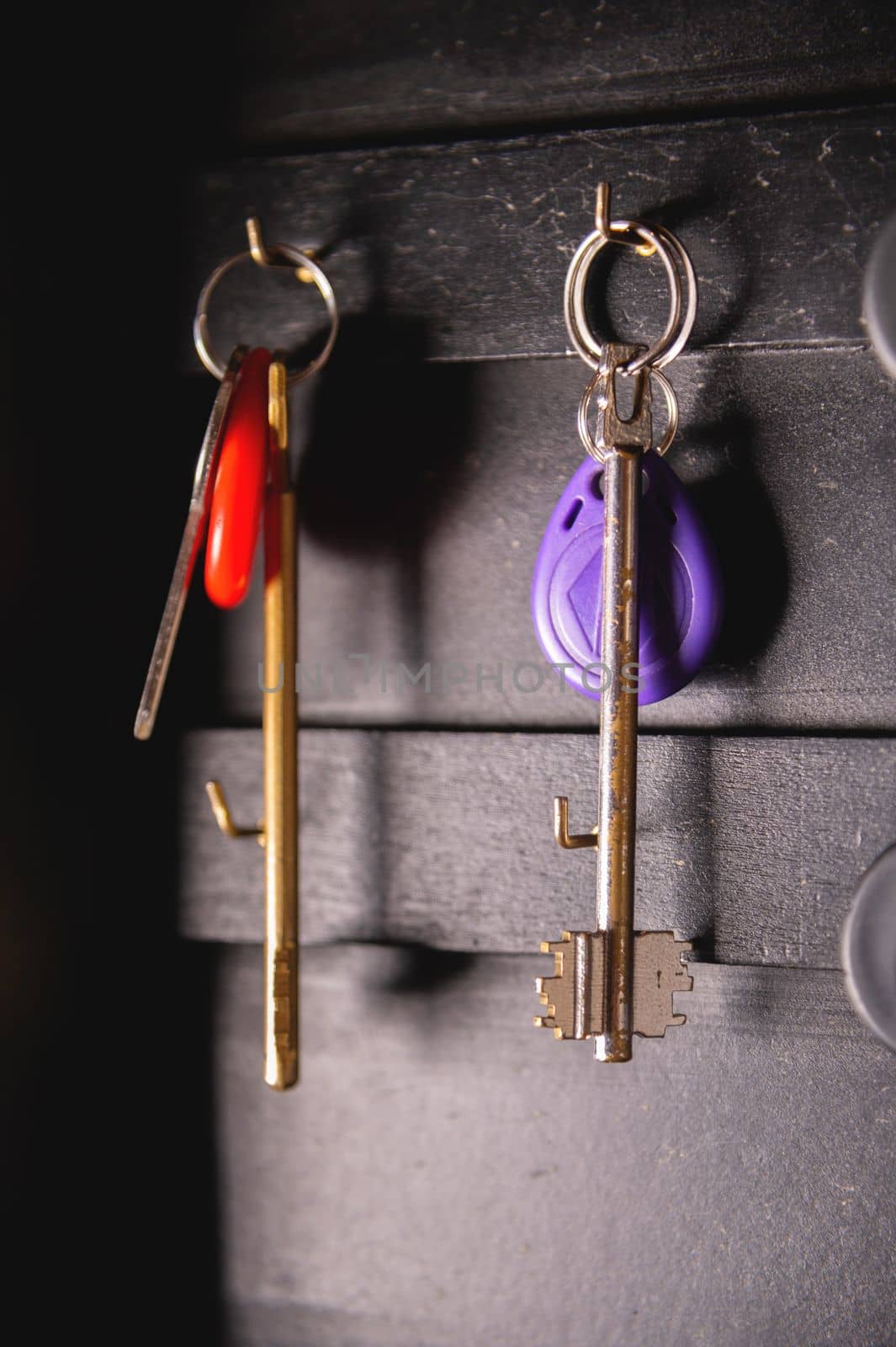 Door key hanging on a wooden key holder, close-up.