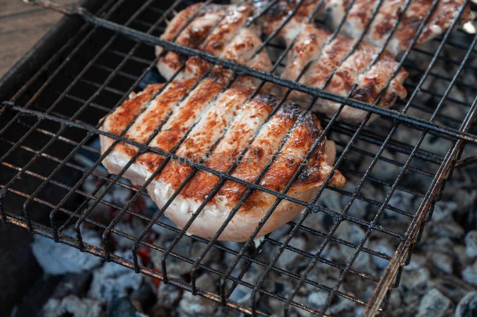 Grilling pork meat on the steel grid. Summer rest concept