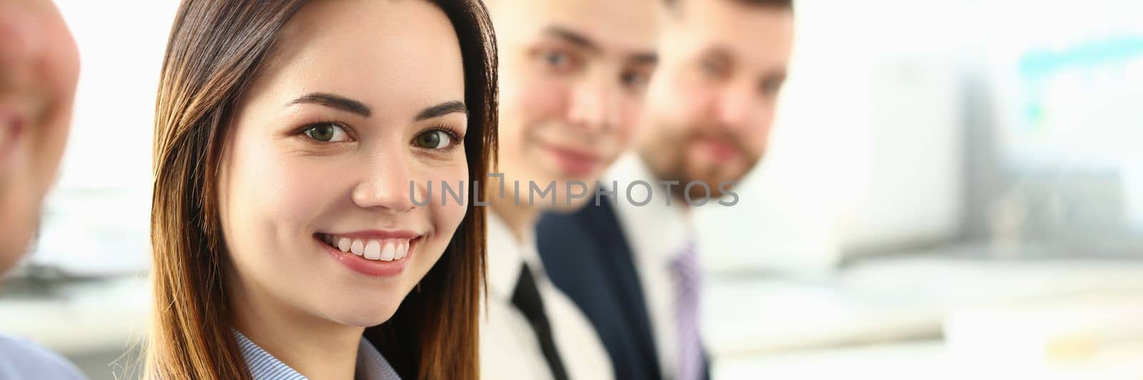 Portrait of pretty young business woman smiling at meeting with colleagues. Collaboration business training and consultation