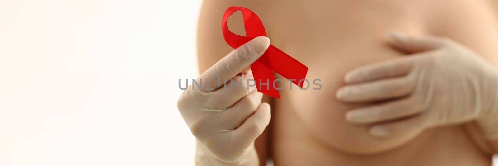 Beautiful naked woman with pink red ribbon on chest. Woman against breast cancer concept