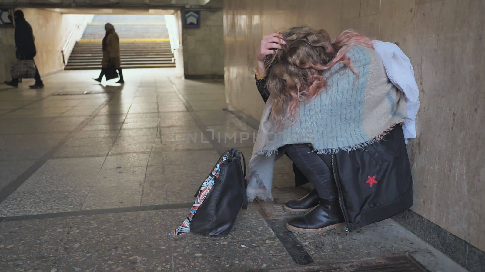 A lonely, sad girl sitting in an underpass