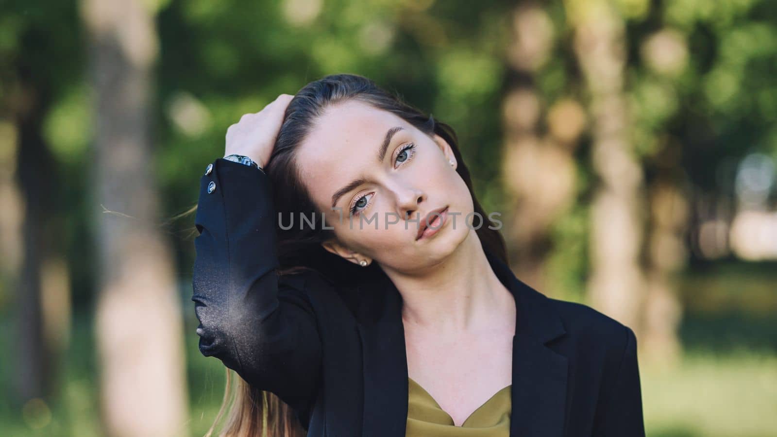 Portrait of a young business girl in a jacket in the park